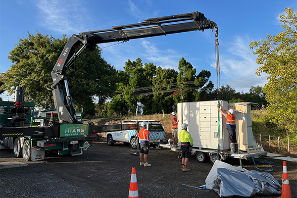 Image of a crane moving a large floodgate pump