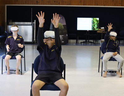 A picture of several children sitting down wearing VR headsets