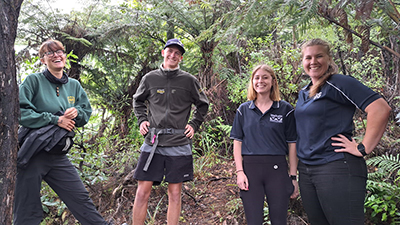 Image of four people standing in a forest