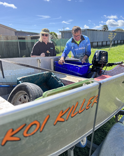 Dawn Metcalfe standing behind the boat Koi Killer