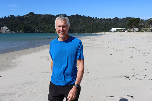 Neil standing in a blue t-shirt on the dune at Whangamata