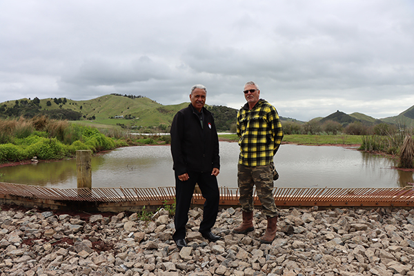 Friends of Lake Kimihia representative Rex Ashby and Waahi Whaanui CE Hori Awa in front of the new weir that ensures a minimum lake level and has a koi barrier.