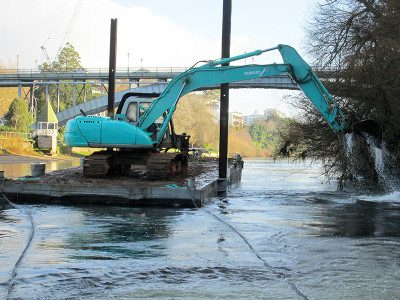 Digger on the back  of the floating platform under the iconic Anzac Parade bridge in Hamilton.