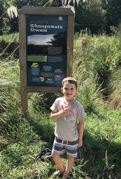 Picture of boy in front of Whangamata Stream sign